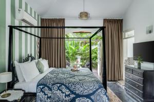 a bedroom with a bed with a blue and white bedspread at Sereno Pearl 3bhk luxury villa with private pool Assagaon in Assagao +63 photos