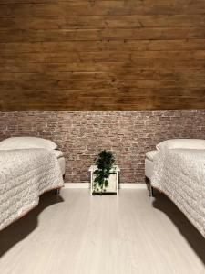 two beds in a room with a brick wall at Slava Hygge Rooms in Nakskov