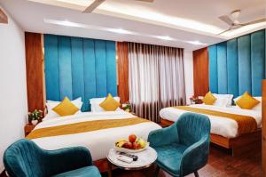 a hotel room with two beds and a table and chairs at Hotel Cabana 5 Mins Walking Distance From NDLS Station in New Delhi