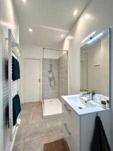 a white bathroom with a sink and a shower at Duplex urbain proche centre-ville de Lyon in Lyon