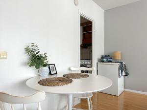 a white kitchen with a white table and chairs at Cozy city suites in Rovaniemi