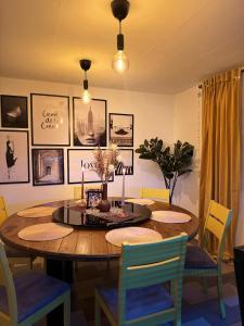 a dining room with a wooden table and chairs at Slava Hygge Rooms in Nakskov