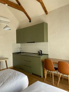 a kitchen with green cabinets and a table and a bed at Tsiskari Cottages in Sadmeli +5 photos
