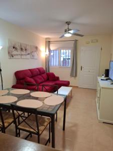 Una sala de estar con un sofá rojo y una mesa. en Casa Zahraa, en Mazarrón