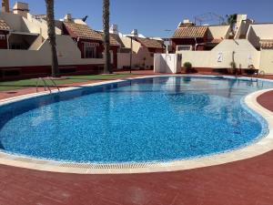 una gran piscina azul frente a algunas casas en Casa Zahraa, en Mazarrón