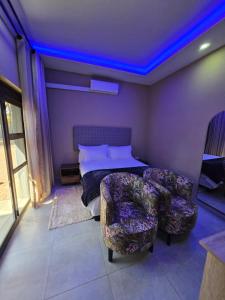 a bedroom with a bed and a couch and blue lights at Cozy Lifestyle Guesthouse in Naboomspruit