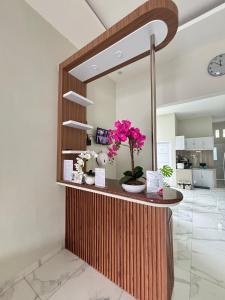 a mirror in a room with a vase of flowers on a counter at OYO 94692 Blower Residence Syariah in Banda Aceh