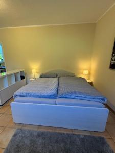 a bed in a bedroom with two lamps on the wall at Haases Ferienwohnung in Remscheid