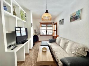 a living room with a couch and a tv at Apartamento Rey Melchor in Trevélez