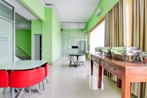 a dining room with red chairs and green walls at OYO 94697 Hotel Amanah Sejahtera in Solo