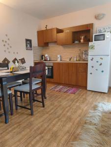 eine Küche mit einem Tisch und einem weißen Kühlschrank in der Unterkunft Evrika home 19 in Pamporowo