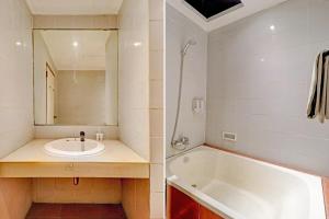 a bathroom with a tub and a sink and a mirror at OYO 94726 Asteria Talaga Bodas in Bandung