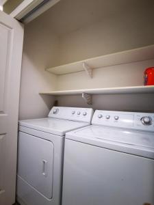 a laundry room with two washers and a dryer at Eagle's Guest Suits in Victoria