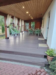 une terrasse en bois avec des tables et des chaises dessus dans l'établissement Zacisze, à Kołczewo