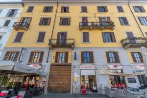 a large yellow building with balconies on a street at The house of Ripa di porta ticinese 13 in Milan