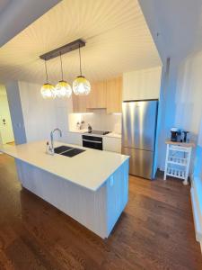 een keuken met een spoelbak en een koelkast bij Dream Apartment in Longueuil