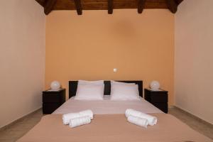 een slaapkamer met een bed met twee handdoeken erop bij Eva Traditional Houses in Volimes in Áno Volímai