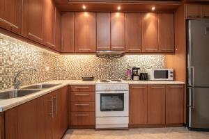 een keuken met houten kasten en een witte kookplaat oven bij Eva Traditional Houses in Volimes in Áno Volímai