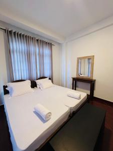 a bedroom with a large bed with towels on it at TranquilZ in Kandy