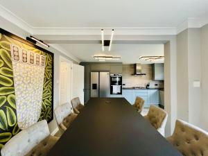 a dining room with a black table and chairs at Poppies in Colchester
