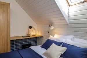 a bedroom with a bed with blue and white pillows at Vila Stinta in Juodkrantė