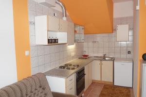 eine kleine Küche mit weißen Schränken und einem Waschbecken in der Unterkunft Apartment Pokos in Varaždinske Toplice