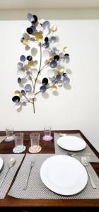 a table with plates and utensils and a plant on the wall at LG318 New Brenthill Premium Condo near SMBaguio in Baguio