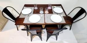 a wooden table with white plates and glasses on it at LG318 New Brenthill Premium Condo near SMBaguio in Baguio +6 photos