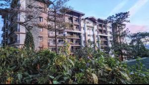 a tall apartment building with plants in front of it at LG318 New Brenthill Premium Condo near SMBaguio in Baguio