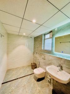 a bathroom with a sink and a toilet and a mirror at Bestinn Leisure Myst Private Villa Ooty in Ooty +53 photos