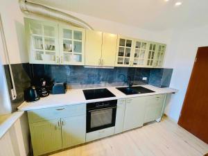 una cucina con mobili bianchi e un lavandino di Panoramablick Ferien- und Monteurwohnung OG a Mörlenbach Altre 5 foto