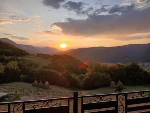 a sunset from a balcony with a view of the mountains at Apartman Sofiana in Bajina Bašta
