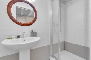 a white bathroom with a sink and a mirror at The house of Ripa di porta ticinese 13 in Milan