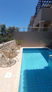 a swimming pool with a table and chairs next to a building at Relax Private Pool House in Maleme
