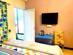a bedroom with a bed and a tv on the wall at Vista villa Where luxury meets comfort MTDC Affiliated in Deolāli