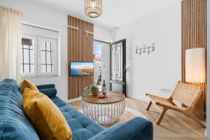 a living room with a blue couch and a table at Casa Rija - Renovated 2BR - Heart of Mijas Pueblo in Mijas