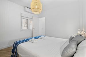 a white bedroom with a white bed and a light at Casa Rija - Renovated 2BR - Heart of Mijas Pueblo in Mijas