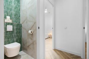 a bathroom with a toilet and green tiles at Casa Rija - Renovated 2BR - Heart of Mijas Pueblo in Mijas +24 photos