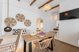 Un comedor con mesa y sillas de madera. en Maroussa's in Town with Sea view, en Naxos Chora