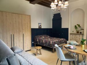 a bedroom with a bed and a table and a couch at Appartement confortable aux Andelys - 90 m² avec parking in Les Andelys