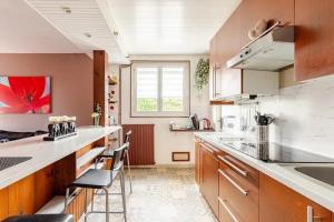 una cucina con un bancone e alcune sedie di Maison avec jardin privé à Plaisance-du-Touch a Plaisance-du-Touch