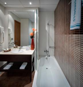 a bathroom with a bath tub and a sink at Hotel Casanova in Fraga