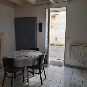 une table et des chaises dans une pièce avec une fenêtre dans l'établissement Maison familiale à Maillé avec vélos, à Maillé