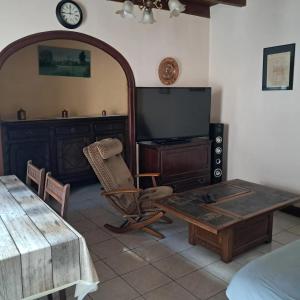 un salon avec une table et une télévision dans l'établissement Maison familiale à Maillé avec vélos, à Maillé