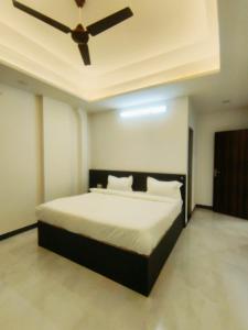 a bedroom with a bed with a ceiling fan at Hotel Connecting Home Stays in Hingni