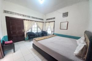 Un dormitorio con una cama y una mesa y sillas. en OYO 94738 Hotel Argo Putro, en Semarang