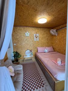 una camera da letto con letto, lenzuola rosa e soffitto di Kaneng Homestaykohpu a Ban Klang