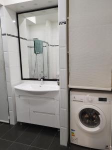 a bathroom with a washing machine and a sink at Siauliai Apartments - Traku in Šiauliai +28 photos