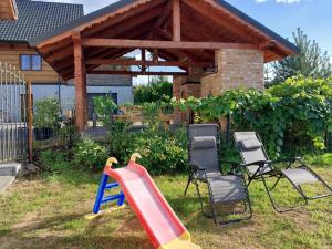 a playground with chairs and a slide in a yard at Agroturystyka Dzika Łąka apartament  +15 photos