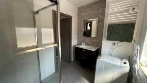 a bathroom with a glass shower and a sink at Appartement moderne 40m2 01 in Folkling